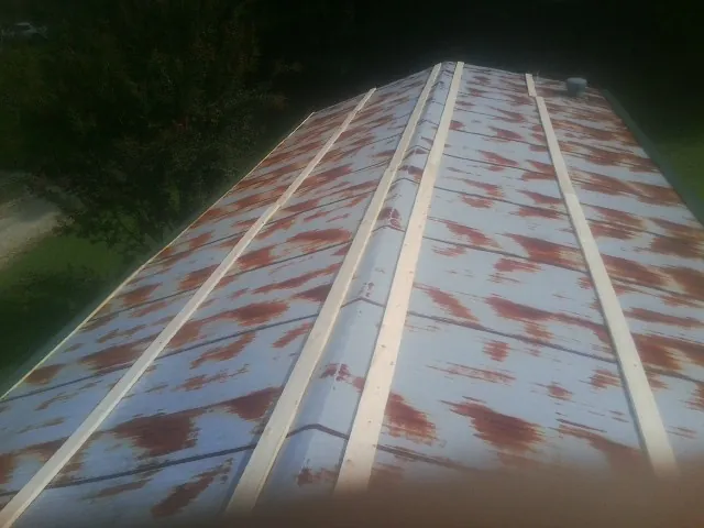 Rusted metal roof panels with new wood purlins before replacement — Storm Damage Roof Repair in Longwood by Roofing Brothers